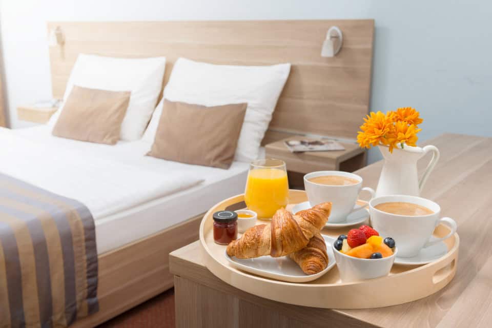 Freshly made hotel with clean linens, breakfast with coffee, juice, and croissants in a boutique Chicago hotel room