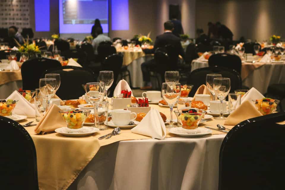 Elegant holiday banquet setup with linens, glassware, and fruit cups at a Chicago event venue, representing Drop & Dash commercial linen service.