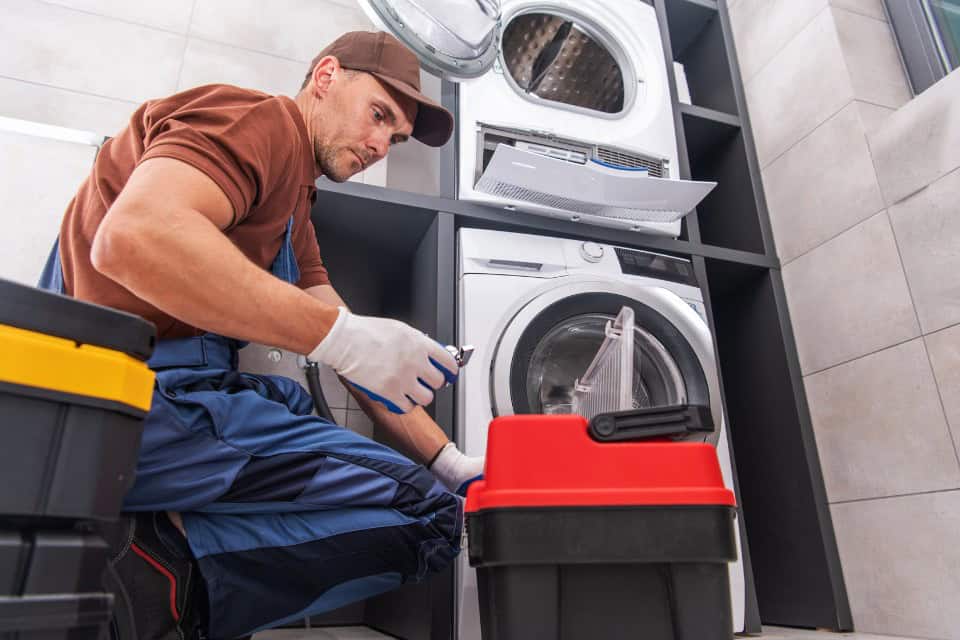 Washer under repair in a commercial setting, highlighting how Drop & Dash steps in with fast laundry service when commercial laundry equipment breaks.